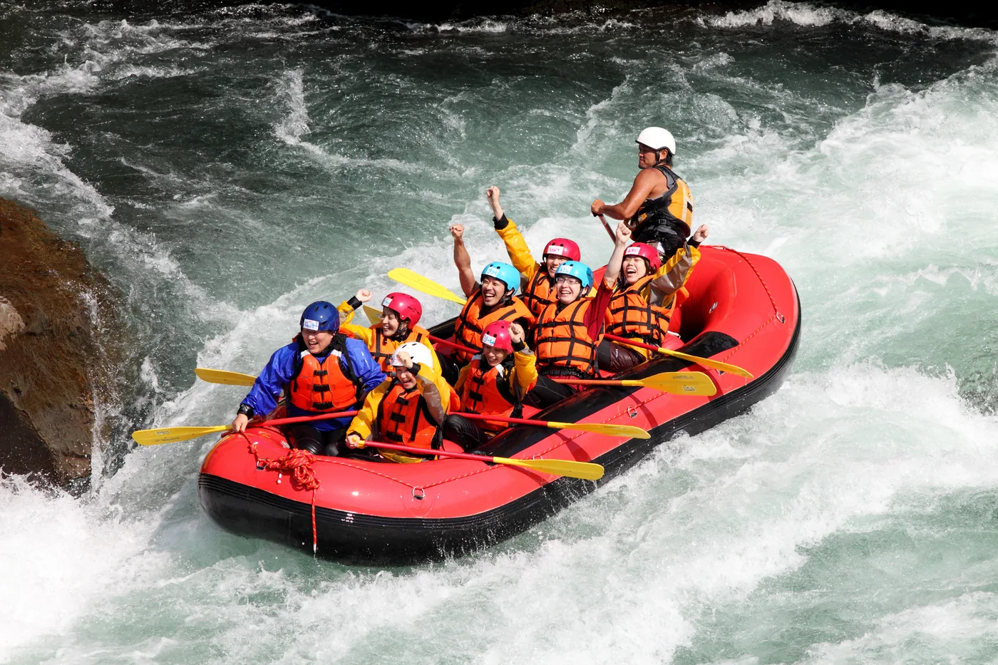 A whitewater rafting group celebrating during their run