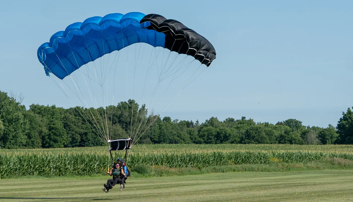 A tandem parachute approaching the landing area